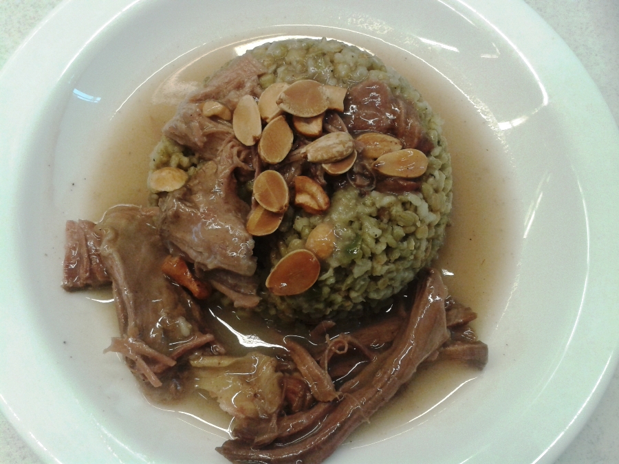 Freekeh with meat, served with nuts and almonds